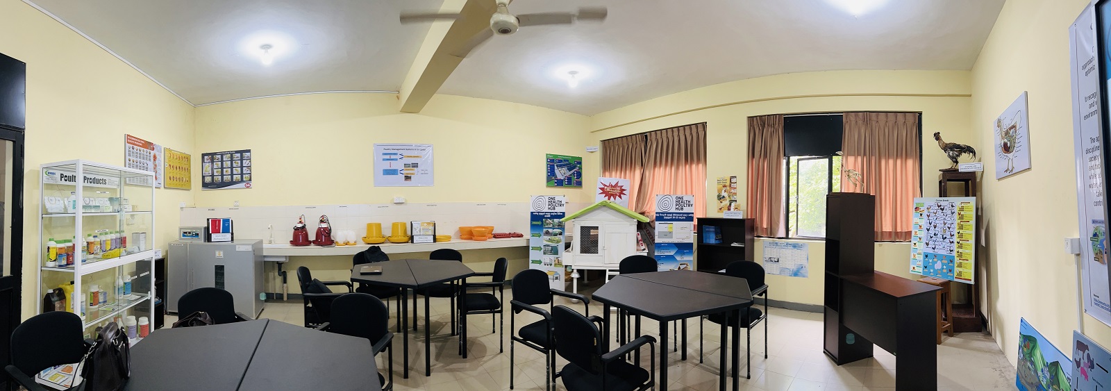 Teaching room with tables, posters on walls and bottles on shelves