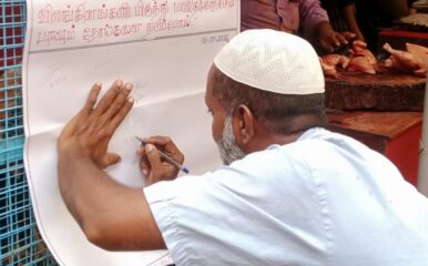 man in cap writing on a large piece of paper pinned to a wall